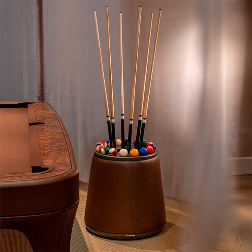 Elegant dark brown Vismara Bobo Cue Rack positioned beside a luxury pool table with wood detailing in a softly lit room.
