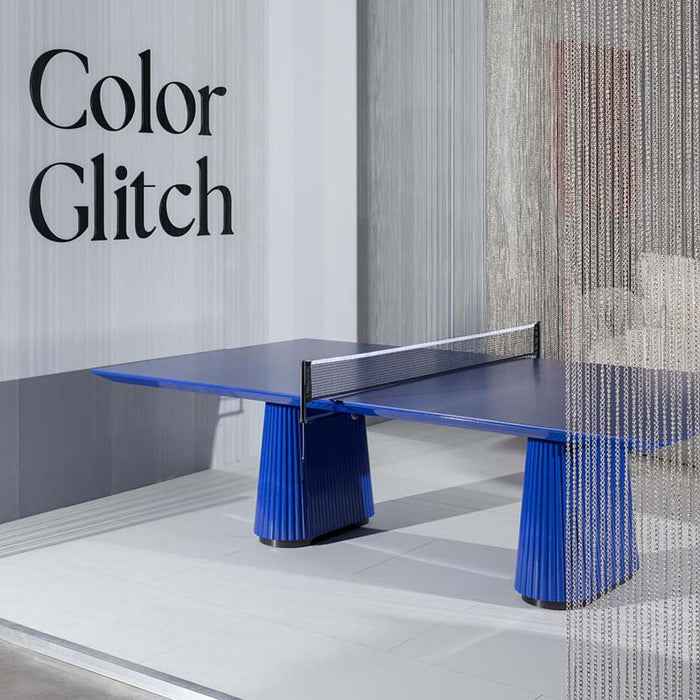 A side view of the Vismara Egeo Table in a vibrant blue finish, displayed in a modern showroom environment.