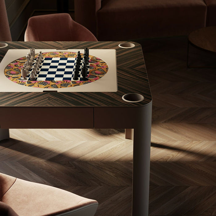 Vismara Enigma table configured for chess with vibrant circular pattern and navy chessboard, paired with velvet chairs – high-end game design with artistic flair.