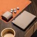 Close-up of Vismara Enigma game table with leather accessories, dice, and pen tray on a rich wood and suede surface – luxury tabletop gaming essentials.