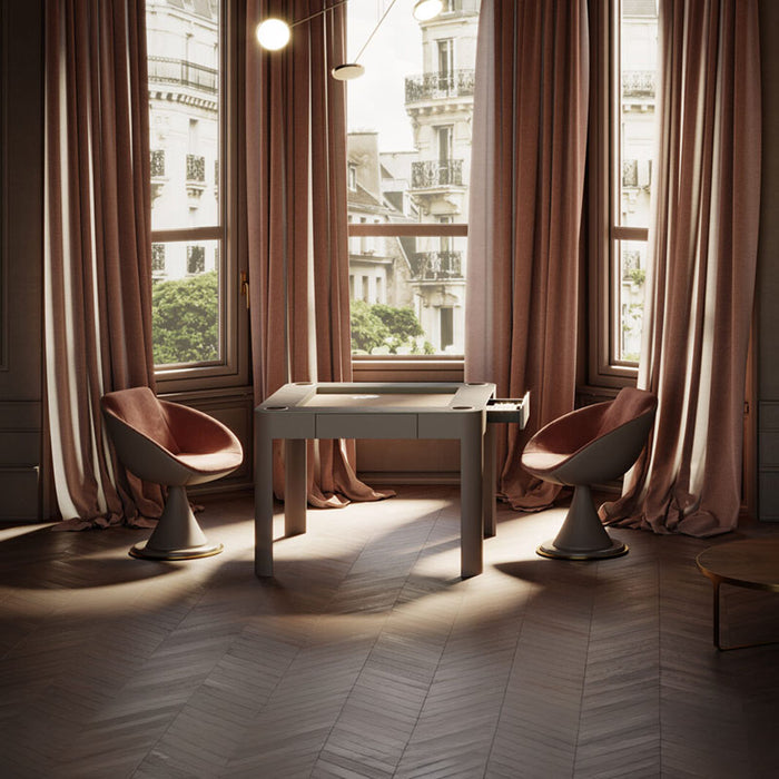 Vismara Enigma game table in a luxurious bay window lounge with rose drapes, designer chairs, and Parisian city view – high-end leisure furniture.