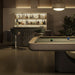 A Mediterranean concrete-finished Mono Pool Table, placed elegantly near a modern bar area.