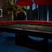 The Vismara Mono Pool Table in a luxurious dim-light setting, highlighting its sleek carbon fibre finish.