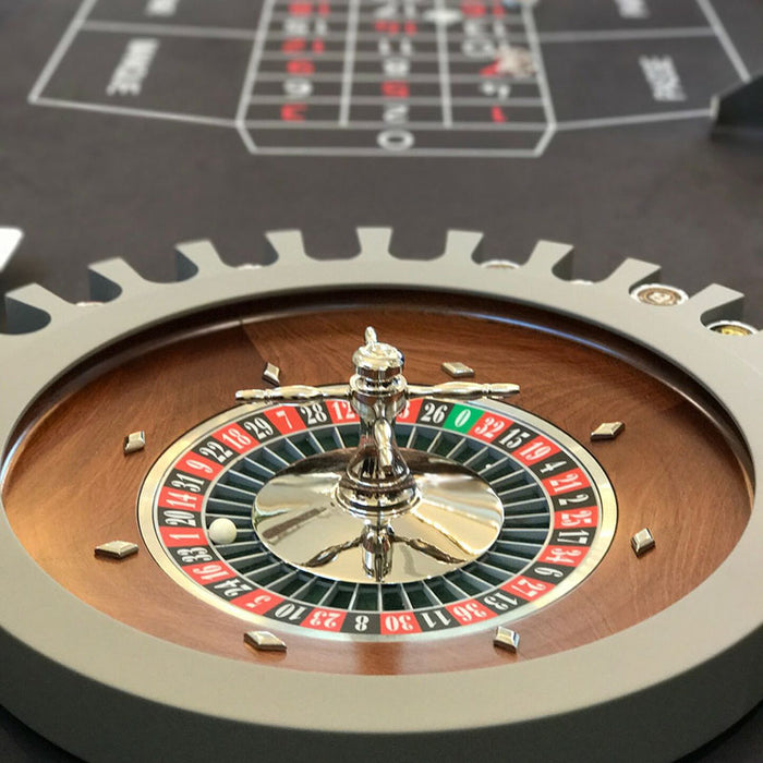 Detailed view of the roulette wheel on Vismara Montecarlo Table with chrome spinner and wooden inlay, black felt betting area in the background – luxury casino elegance.