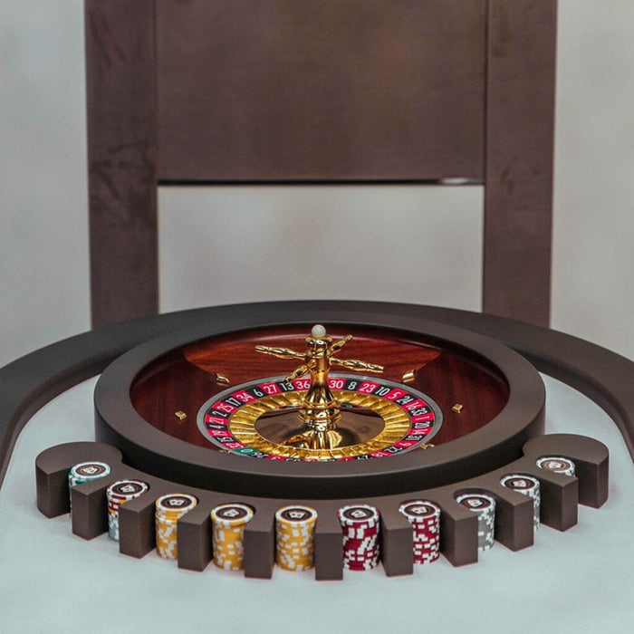 Golden fan wall art above the Vismara Montecarlo Roulette Table with rich mahogany wheel and colour-coded chip arrangement – refined luxury detail.