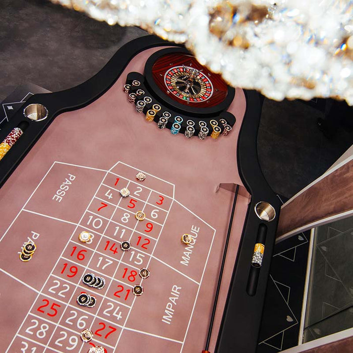 Close-up of Vismara Montecarlo Roulette Table with mauve betting layout, luxury chips, polished wheel and crystal chandelier – premium home casino setting.