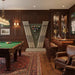 Vismara Newde Cue Rack in a classic wood-panelled games room with vintage decor, leather seating, and luxury pool table setup.
