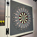 Detailed close‑up of the Vismara Nido Dartboard Cabinet showing the dartboard graphic with numbered scoring zones and dart tips against a stylish patterned backdrop.