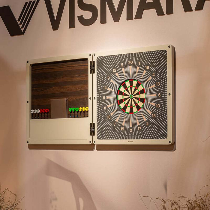 Vismara Nido Dartboard Cabinet displayed open on a blush pink wall, featuring precision-designed dartboard, rich wood backing, and neatly arranged multicoloured darts.