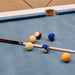 Close-up of vibrant pool balls and a professional cue resting on the smooth blue playing surface of the Vismara Regis Pool Table.