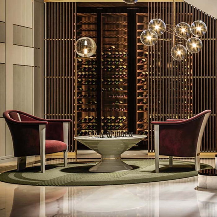 Vismara Scaccomatto Chess Tables in a grand double-height room with central staircase, designer lighting, and bespoke wine cellars – perfect for luxury hospitality spaces.