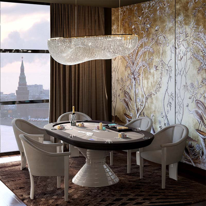 Elegant oval Vismara Vegas poker table in a lavish interior with suede armchairs and chandelier lighting, ideal for premium home casino rooms.