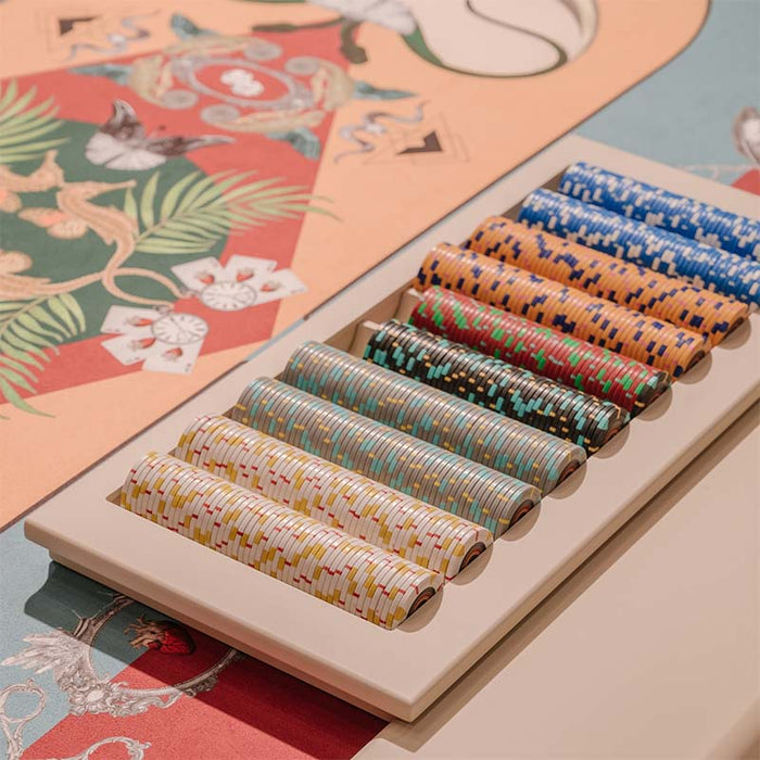 Close-up of colourful casino chips arranged neatly on a custom Vismara Vegas poker table with artistic felt design.