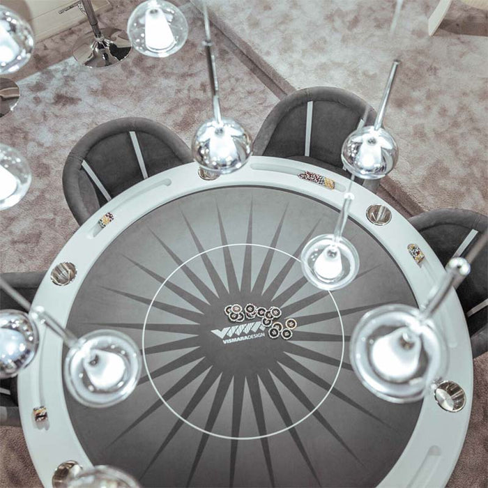 Top-down view of the Vismara Vegas round poker table with elegant dark felt and chrome light fixtures, styled for premium gaming.