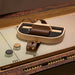 Detailed shot of Vismara Flume shuffleboard accessories with leather‑trimmed case and polished pucks on a refined playing surface – designer game set for luxury interiors.