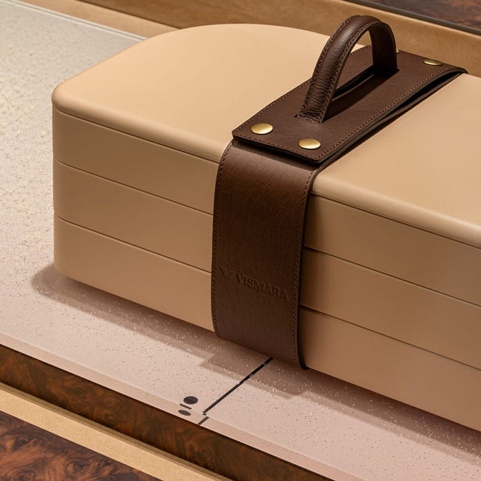 Close‑up of high‑quality Vismara Flume shuffleboard table puck box with leather handle and subtle branding on textured playing field – premium shuffleboard detail.