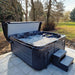 Side view of Wellis Valencia Hot Tub in use outdoors, bubbling water and natural setting highlight premium hot tub experience.