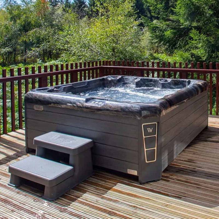Wellis Valencia Hot Tub installed on wooden decking with lush forest views, blending spa luxury with nature escapes.