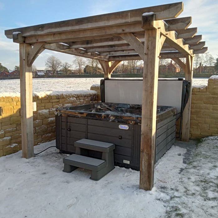 Wellis Valencia 7 Person Hot Tub installed under wooden pergola during winter, perfect for holiday parks and cold-weather spa retreats.