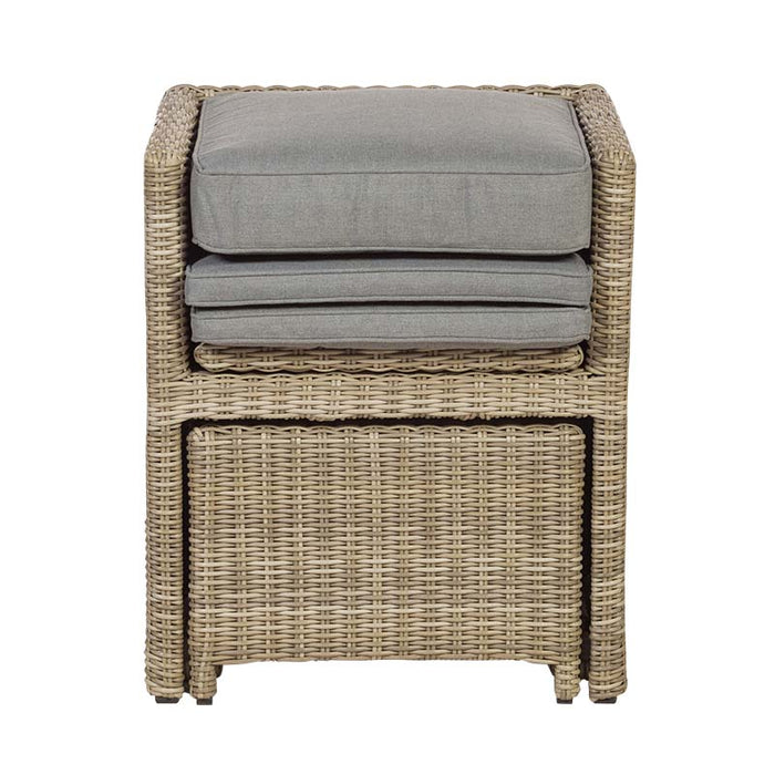 Front view of the stacked rattan chair and cushion from the Wentworth 10 Seater Cube Dining Set, emphasizing the space-saving design.