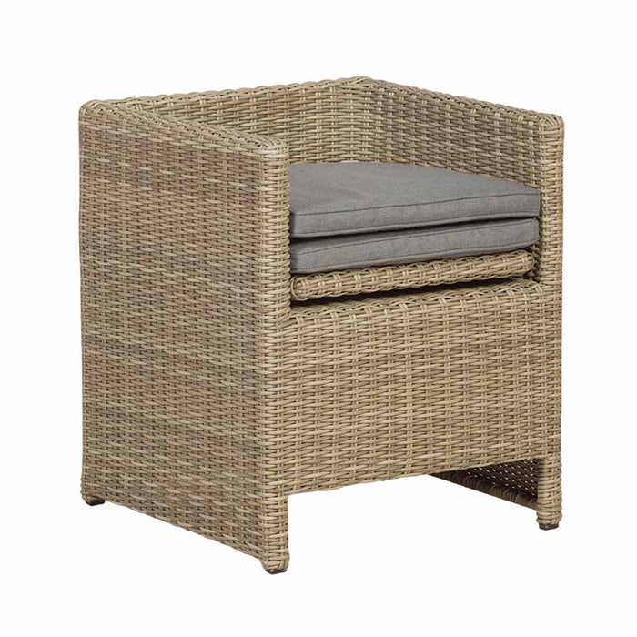 Angled view of the Wentworth 10 Seater Cube Dining Set chair, featuring durable rattan weave and neatly stacked cushions.