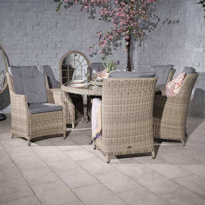 A side view highlighting the elegant rattan chairs and glass-top oval table of the Wentworth 6 Seater Ellipse Imperial Dining Set in a stylish indoor setting.