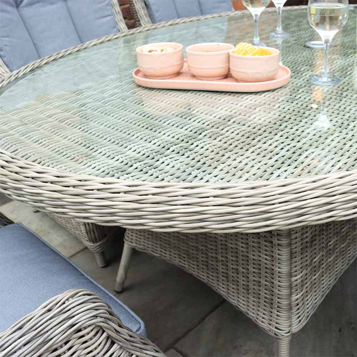 A close-up view of the glass-top oval table from the Wentworth 6 Seater Ellipse Imperial Dining Set, highlighting the intricate rattan weave and elegant finish.