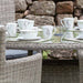 A close-up of the Wentworth 6 Seater Round Carver Dining Set, featuring its elegant tableware setup, highlighting its suitability for outdoor dining.