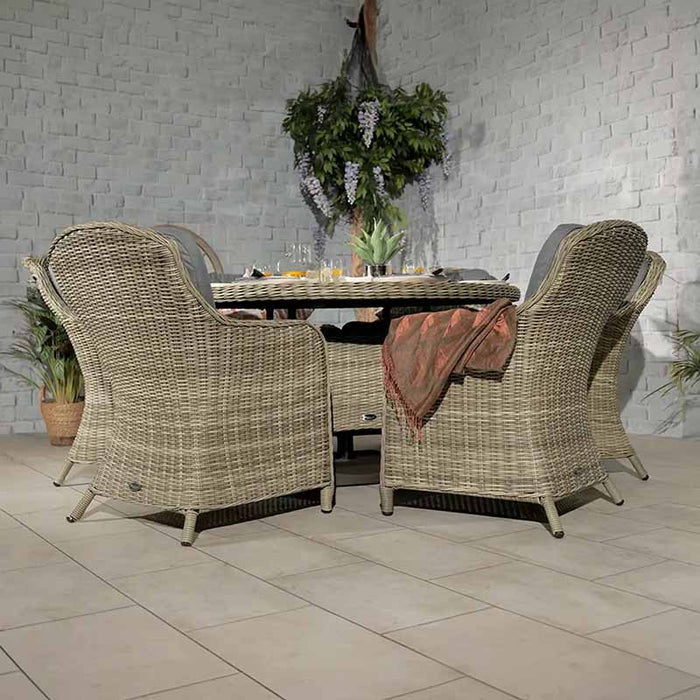 Rear view of the Wentworth 6 Seater Round Imperial Dining Set in an indoor setting, featuring rattan chairs with grey cushions around a glass-topped round table.