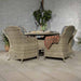 Rear view of the Wentworth 6 Seater Round Imperial Dining Set in an indoor setting, featuring rattan chairs with grey cushions around a glass-topped round table.