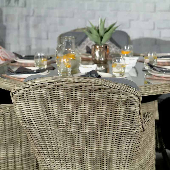 Rear view of the Wentworth 6 Seater Round Imperial Dining Set's rattan chairs, highlighting the elegant weave and comfortable grey cushions.