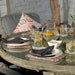 Close-up of the dining table setup in the Wentworth 6 Seater Round Imperial Dining Set, featuring a jug of citrus water and stylish place settings.