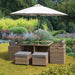 Wentworth 8 Seater Cube Dining Set with parasol, elegantly arranged in a lush garden setting for outdoor dining.