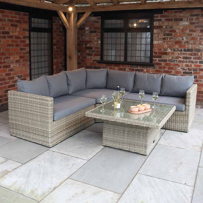 Cosy outdoor setup with the Wentworth Adjustable Corner Lounge Set, featuring grey cushions and a wicker frame under a pergola.