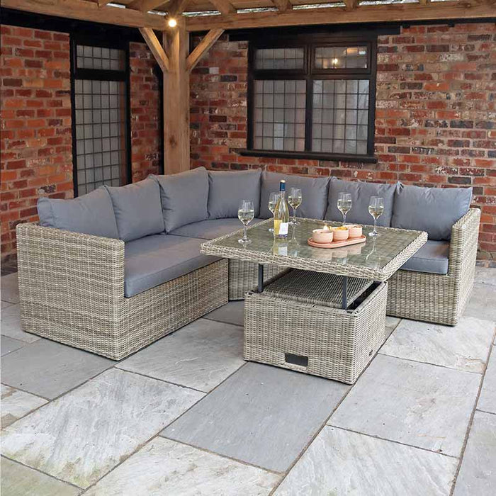 The Wentworth Adjustable Corner Lounge Set styled in a patio area, showcasing the modular sofa and elegant glass-topped table.