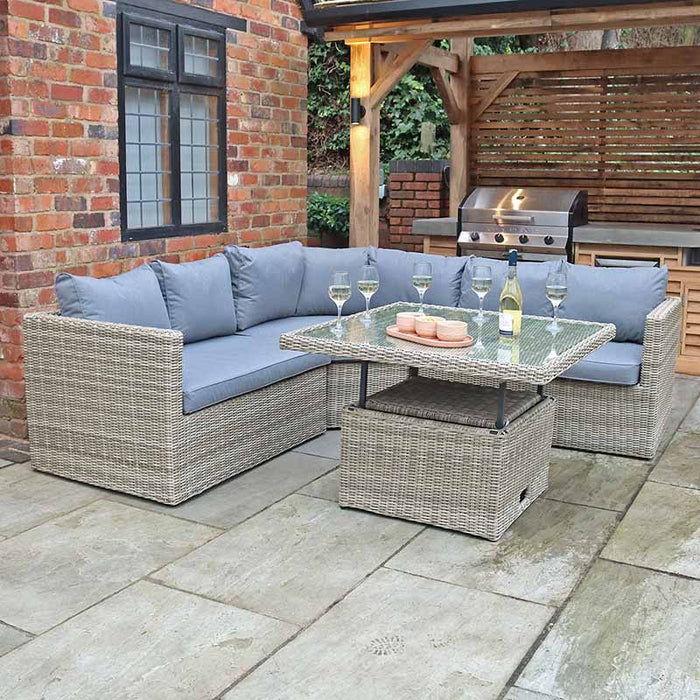 Close-up of the Wentworth Adjustable Corner Lounge Set in an outdoor area, focusing on the glass-topped adjustable table.