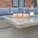 The Wentworth Adjustable Corner Lounge Set arranged in an outdoor setting, featuring a grey cushion sofa and glass-topped table.