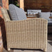 Side view of the Wentworth Deluxe Sofa armchair, highlighting the intricate rattan design and plush grey cushion.