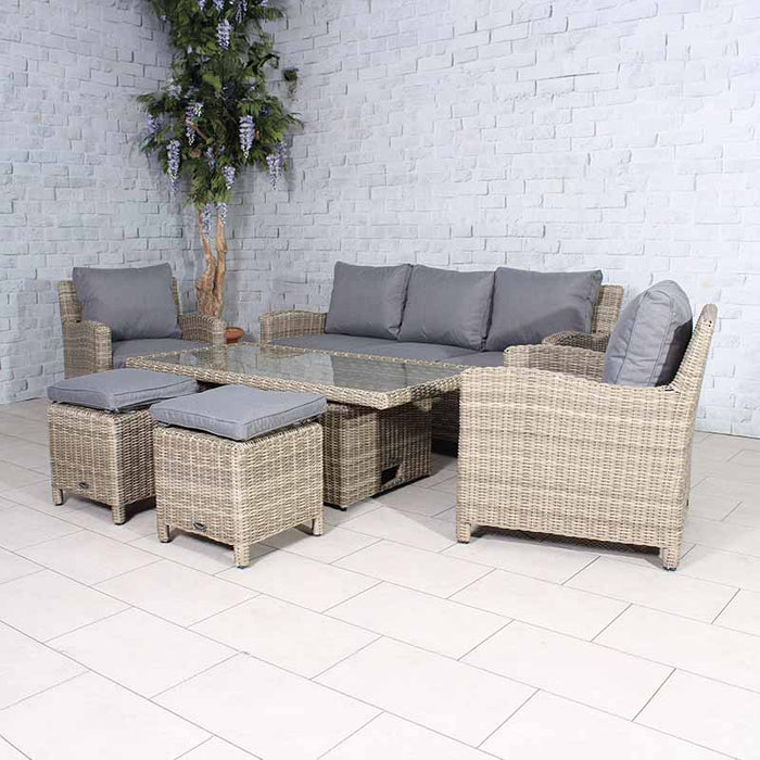 Wentworth Deluxe Sofa Dining Set highlighting a large rattan sofa, armchairs, and footstools with grey cushions, centred around a rectangular glass-top dining table.