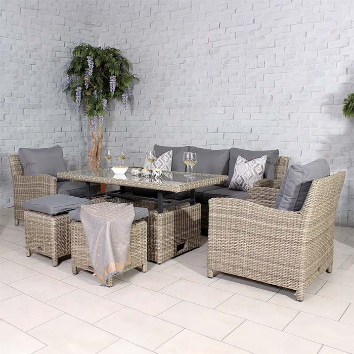 Elegant setup of the Wentworth Deluxe Sofa Dining Set featuring wicker furniture with a glass-top dining table, cushioned seating, and decorative accents in a neutral-toned room.