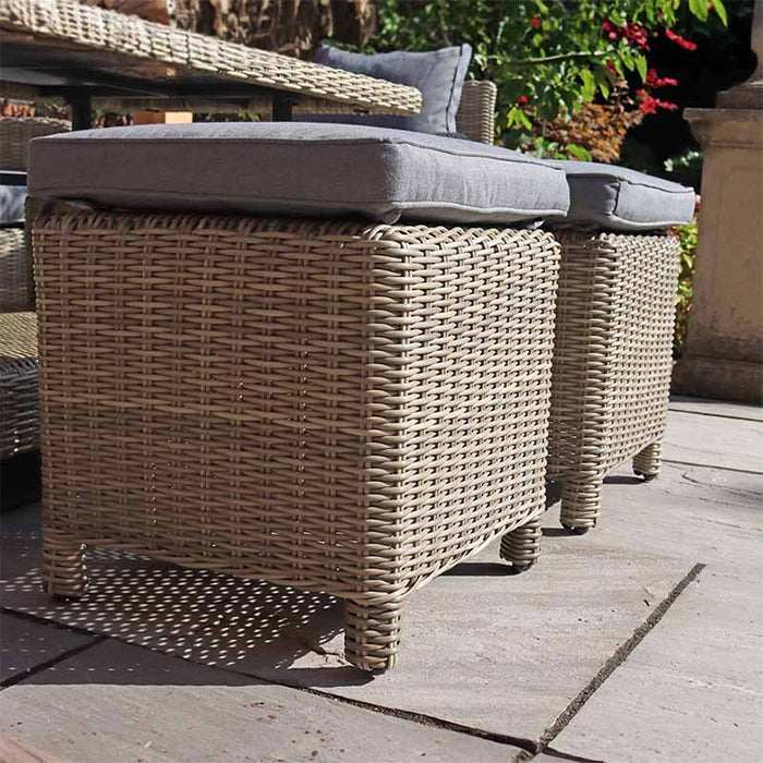 Close-up of the Wentworth Deluxe Sofa Dining Set’s rattan footstools with grey cushions, showcasing the detailed weave and sturdy construction.