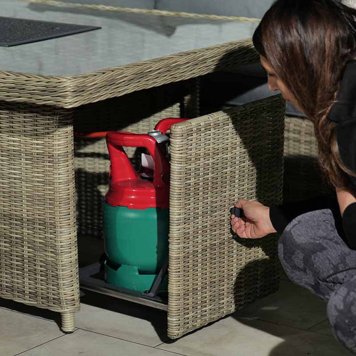 Hidden compartment in the Wentworth Fire Pit Corner Dining & Lounge Set's rectangular table, used for storing a propane gas cylinder discreetly.