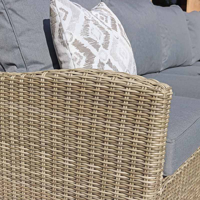 Detailed view of cushions arranged on the rattan sofa of the Wentworth Fire Pit Dining & Lounge Set, perfect for a comfortable seating experience.