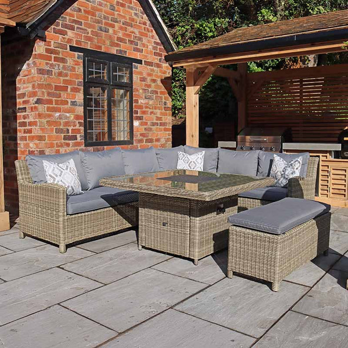 Wentworth Fire Pit Dining Set with Square Table, set against a rustic brick wall ideal for luxurious outdoor lounging and dining.