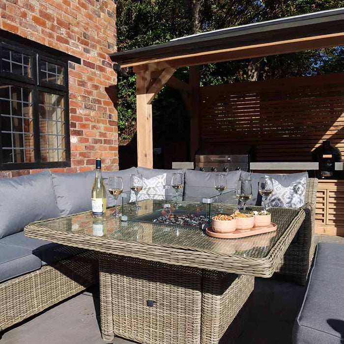 Wentworth Fire Pit Dining & Lounge Set with square table set in a rustic backyard, showcasing a perfect spot for outdoor dining and relaxation.