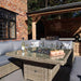 Wentworth Fire Pit Dining & Lounge Set with square table set in a rustic backyard, showcasing a perfect spot for outdoor dining and relaxation.