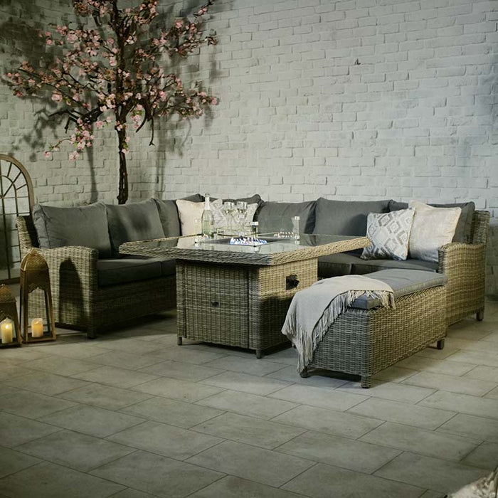 Wentworth Fire Pit Dining & Lounge Set with square table, featuring a cosy rattan corner sofa and stylish decor for a warm evening setting.