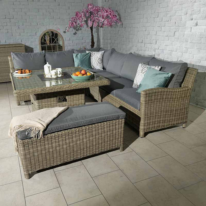 Wentworth Fire Pit Dining & Lounge Set with square table, featuring a cosy indoor setup with rattan furniture and decorative cushions.