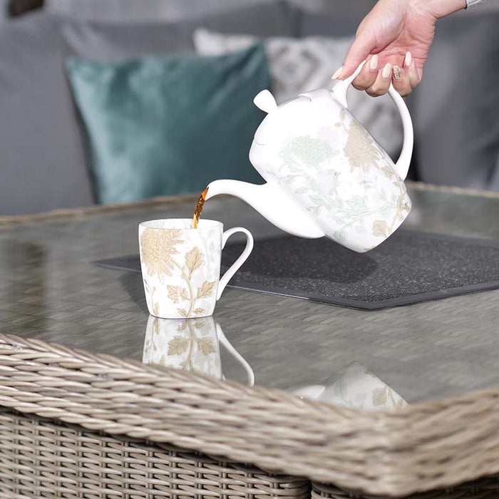 Pouring tea into a floral cup on the Wentworth Fire Pit Dining Set’s square table, highlighting a serene outdoor dining moment.