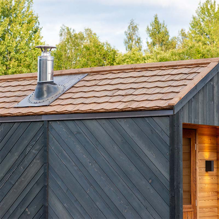 Woodnest Alice 2-3 Person Outdoor Sauna roof detail with natural wood shingles, metal chimney and dark timber cladding.